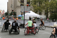 Photo of a wheelchair basketball game being played outside.